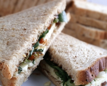 Standard lunch box with deli sandwich, apple, and cookie by Canuel Caterers